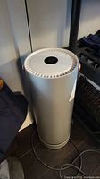 Grey Molekule Air Purifier standing upright showing top radial vent and housing