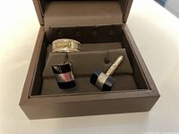 View of sterling silver ring and matching black onyx cuff links in a brown jewelry box.
