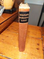 Spine view of the book showing title label "Milton's Paradise Lost" in gold lettering on black background with brown spine.