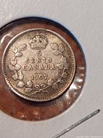 Close-up photo of the reverse side of the 1907 Canadian Silver Five Cents coin showing the denomination, maple leaf wreath, and crown detail with date 1907.