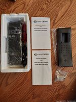 Curtis CB-090 radio in white foam insert with black battery charger, instruction manuals, and small screws in plastic bag.