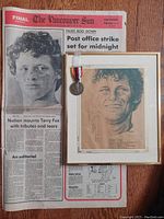 Framed pencil drawing of Terry Fox with medal attached and a vintage newspaper front page from The Vancouver Sun about Terry Fox.