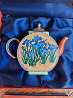 Hand-painted teapot figurine displayed in presentation box on blue satin