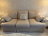 Front view of Barrymore couch with patterned light beige cushion covers and matching throw pillows placed on seat and arms.