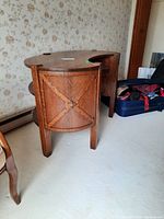 Side view of a kidney-shaped wood desk showcasing decorative paneling on the side.