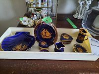 Tray of 8 Limoges porcelain pieces including shell plate, small beer stein, trinket boxes, and decorative plates in cobalt blue with gold accents.
