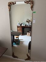 Full view of the mirror in a room reflecting surrounding furniture and decor.