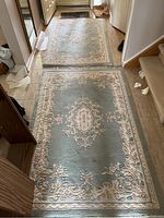 Two area rugs placed on a tiled hallway floor showing pattern and colors