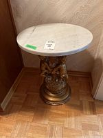 Full view of round table showing marble top and gold-tone cherub base