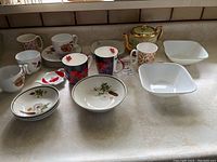 Full display showing all items including teapot, mugs, bowls, cups and saucers on counter.