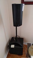 Tall Boston speaker on black stand with mesh grille and Boston label