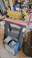 Two foldable work benches stacked with plastic hardware organizers in front.