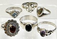 Six sterling silver rings with different semi-precious stones displayed together.