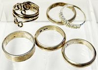 View of all six sterling silver rings marked 925 in varied designs and sizes.