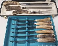 Photo of 3-piece carving set in a lined case with large knife, carving fork, sharpening steel, all with antler handles.