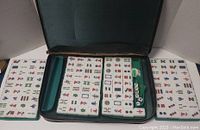 Overview of Mahjong set inside the open carrying case, showing multiple rows of Mahjong tiles arranged inside.