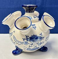 Front and side view of the ceramic vase showing footed base and blue floral decoration