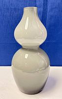 Front and side view of the double-bulbous white cased glass vase with smoky gradient and shiny surface.