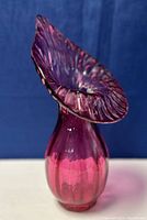 Front angled view of cranberry glass jack-in-the-pulpit vase showing bulbous body and ruffled top.