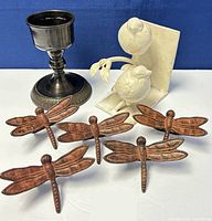 Photo of vintage metal candleholder, bird bookend, and five butterfly-shaped napkin holders.