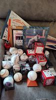 Wide view showing signed and commemorative baseballs, framed photos, plaques, and several pennants stacked behind.