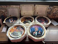 Overview of five Frank Sinatra collector plates in white foam packaging with three Certificates of Authenticity behind them