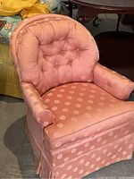 Front angle showing tufted back, armrests, cushioned seat, and fabric pattern.