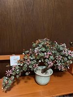 Side view of the mixed gemstone bonsai tree with decorative foliage and flowers in a patterned ceramic pot.