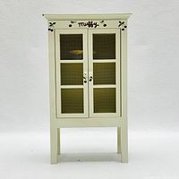 Front view of closed miniature pantry cabinet showing wire mesh doors and Muffy painted top with cherry decoration