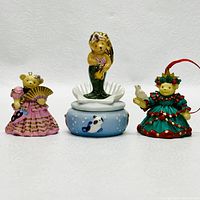 Front view of three Muffy Vanderbear items: two figurines and one container with mermaid bear on top.