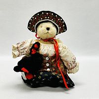 Front view of Muffy VanderBear dressed as Czarina Muffina holding the black swan plush.