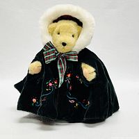 VanderBear plush bear in black embroidered winter coat with fur hood and plaid bow, front view on white background