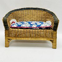 Front view of VanderBear wicker bench with a colorful blue cushion on the seat, highlighting the woven wicker pattern and structure.