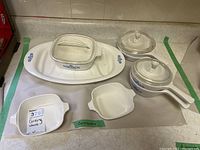 Photo showing overall lot contents including casserole dish, platter, saucepans, and small dishes with blue cornflower pattern.