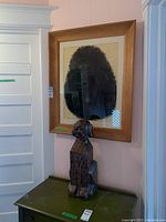 Framed pastel of black poodle seen on wall above green painted furniture, wooden frame visible