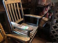 Vintage wooden rocking chair showing wear with peeling paint and signs of age.