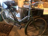 Full side view of green Raleigh Supreme bicycle with accessories