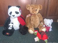 Photo showing the full group of stuffed animals including the Gund Panda, Smithsonian Teddy Bear, small white teddy, Hersheys Kiss bear, and Pier 1 turtle on wood background.