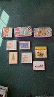 Overview of multiple boxes and containers filled with assorted Christmas gift tags and greeting cards with festive designs including Christmas trees, drums, birds