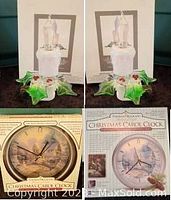 Photo showing the Thomas Kinkade Christmas Carol Clock in its original box, and one decorative candle nightlight with green holly leaves and red berries at the base.