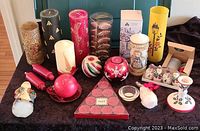 Wide view of all assorted Christmas candles in the lot displayed on black cloth