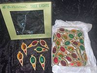 Box and loose plastic jewel-tone Christmas tree light covers.