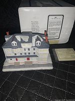 Front view of The Red Lion Inn ceramic building with detailed roof, windows, base, and box shown in background