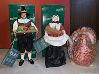 Pair of fabric mache pilgrim figurines and ceramic turkey gray boat with original Midwest Importers box background.
