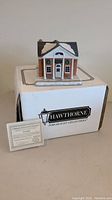 Handcrafted porcelain Christmas village sculpture on white box with certificate shown