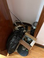 Lot of five appliances including a Bionaire humidifier, Fellows paper shredder, Eureka vacuum, bathroom scale, and floor fan arranged on floor near doorway.