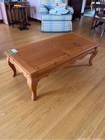 Wood coffee table angled view showing the rectangular top and cabriole legs.