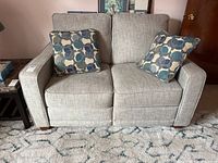 Front view of loveseat with two throw pillows on top