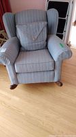 Front view of the blue striped wing back upholstered rocking chair with cushion.