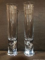 Front view of two identical clear crystal glasses 11 inches tall with solid bases and swirl designs inside the bases.